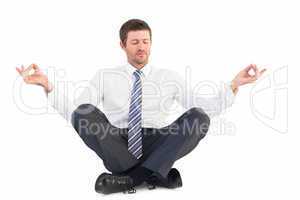 Businessman meditating in lotus pose
