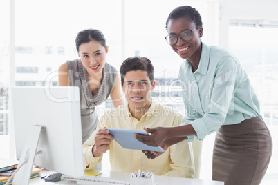 Casual business team looking at tablet together