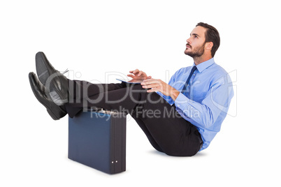 Businessman sitting with feet up while using his tablet