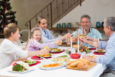 Family toasting with white wine in a christmas dinner