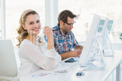 Casual photo editor working at desk smiling at camera