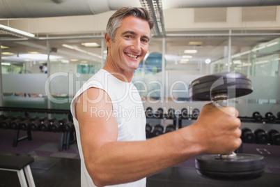 Fit man lifting heavy black dumbbell