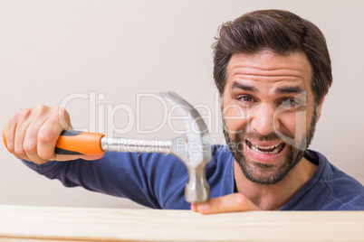 Casual man hammering his finger by accident