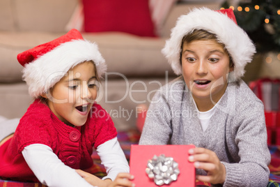 Shocked brother and sister opening a gift