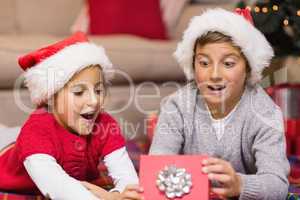 Shocked brother and sister opening a gift