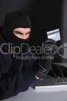 Angry hacker using credit card and laptop