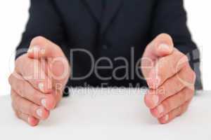 Mid section of a businessman with hands on a table