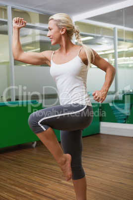 Smiling young woman doing power fitness exercise