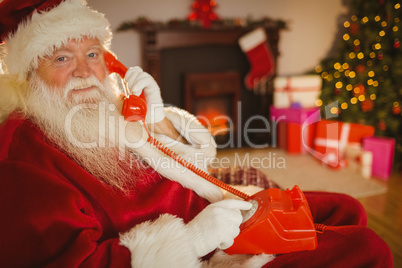 Smiling santa making a phone call