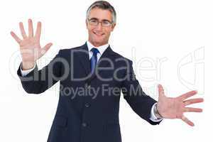 Smiling businessman in glasses with arms out
