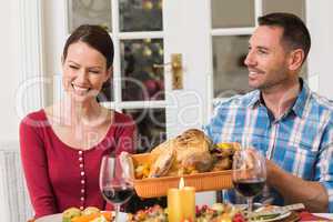 Smiling couple while man holding rast turkey
