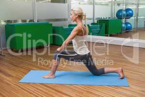 Fit woman doing stretching exercise in gym