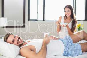 Young couple having breakfast in bed