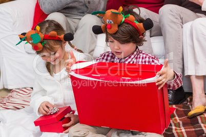 Festive sibling opening a gift