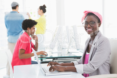 Young creative woman using laptop at desk