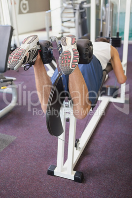 Fit man using weights machine for legs