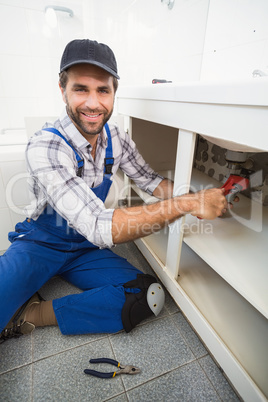 Plumber fixing under the sink