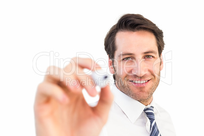 Smiling businessman writing with black marker