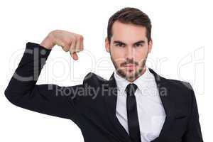 Businessman tensing arm muscle and looking at camera