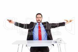 Unsmiling businessman sitting with arms outstretched