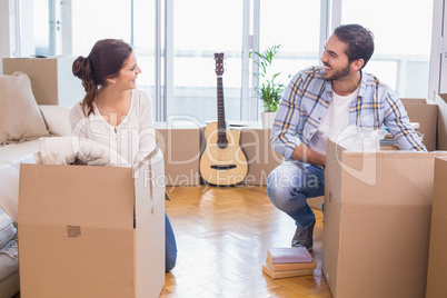 Cute couple unpacking cardboard boxes