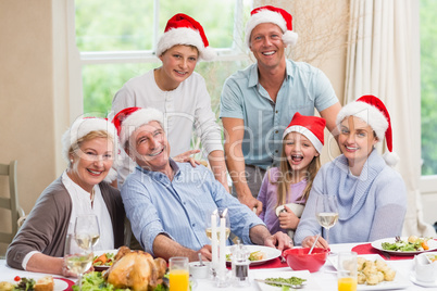 Happy family in santa hat looking at camera