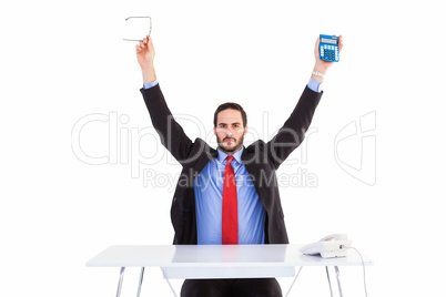 Businessman holding up reading glasses and calculator