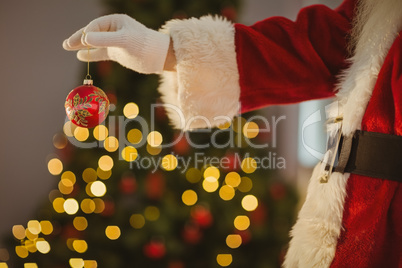 Hand of santa holding a bauble