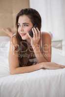 Pretty brunette talking on the phone in bed