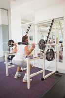 Fit man lifting heavy barbell