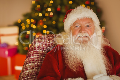 Content santa relaxing on the armchair