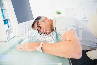 Man with glasses sleeping on the keyboard