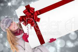 Happy blonde in winter clothes showing card