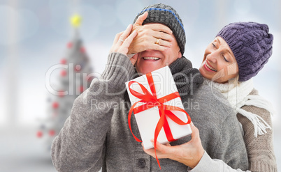 Composite image of mature woman surprising partner with gift