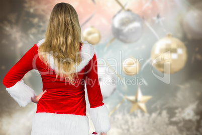 Composite image of pretty girl in santa outfit holding gift