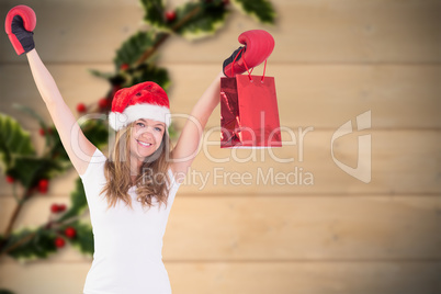 Composite image of festive blonde with boxing gloves and shoppin