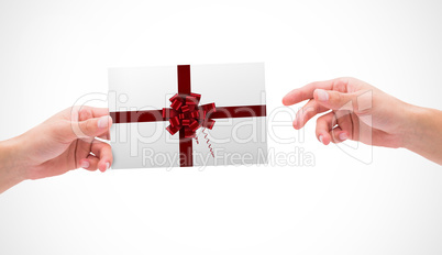 Composite image of hands holding card