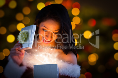 Composite image of sexy santa girl opening gift