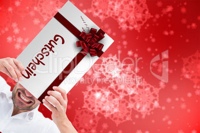 Composite image of festive man holding christmas gift Composite image of festive man holding christmas gift