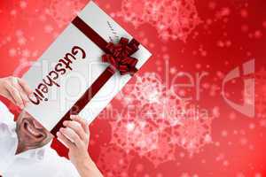 Composite image of festive man holding christmas gift