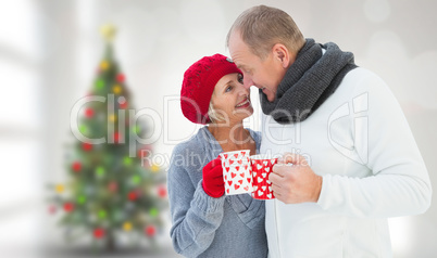 Composite image of mature couple holding mugs