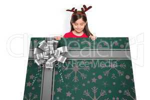 Composite image of festive little girl showing card