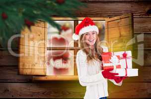 Composite image of festive blonde holding pile of gifts