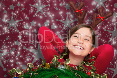 Composite image of festive little girl wearing antlers