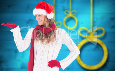 Composite image of festive blonde presenting with hand