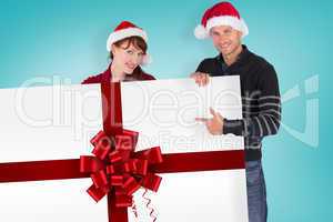 Composite image of couple holding a white sign