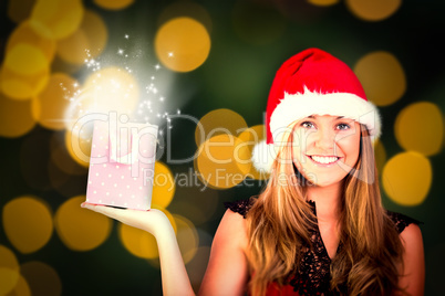 Composite image of festive blonde holding a gift bag