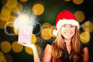 Composite image of festive blonde holding a gift bag