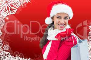 Composite image of festive brunette holding shopping bag