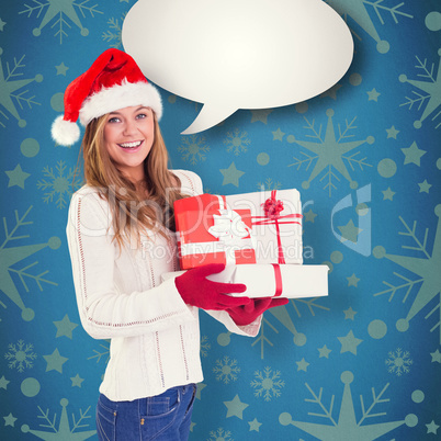 Composite image of festive blonde holding pile of gifts